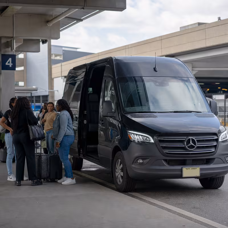 Group boarding a white charter bus for Airport Transportation transportation in Newark