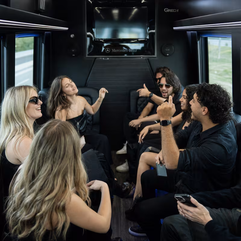 Group boarding a white charter bus for Concert Transportation transportation in Newark