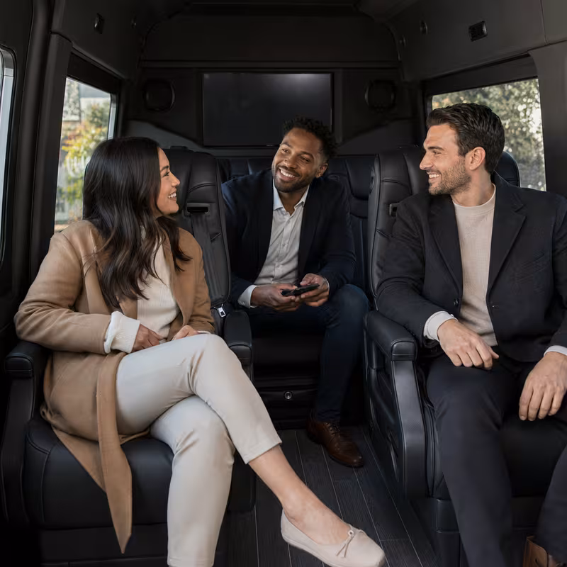 Group boarding a white charter bus for Corporate Transportation transportation in Newark