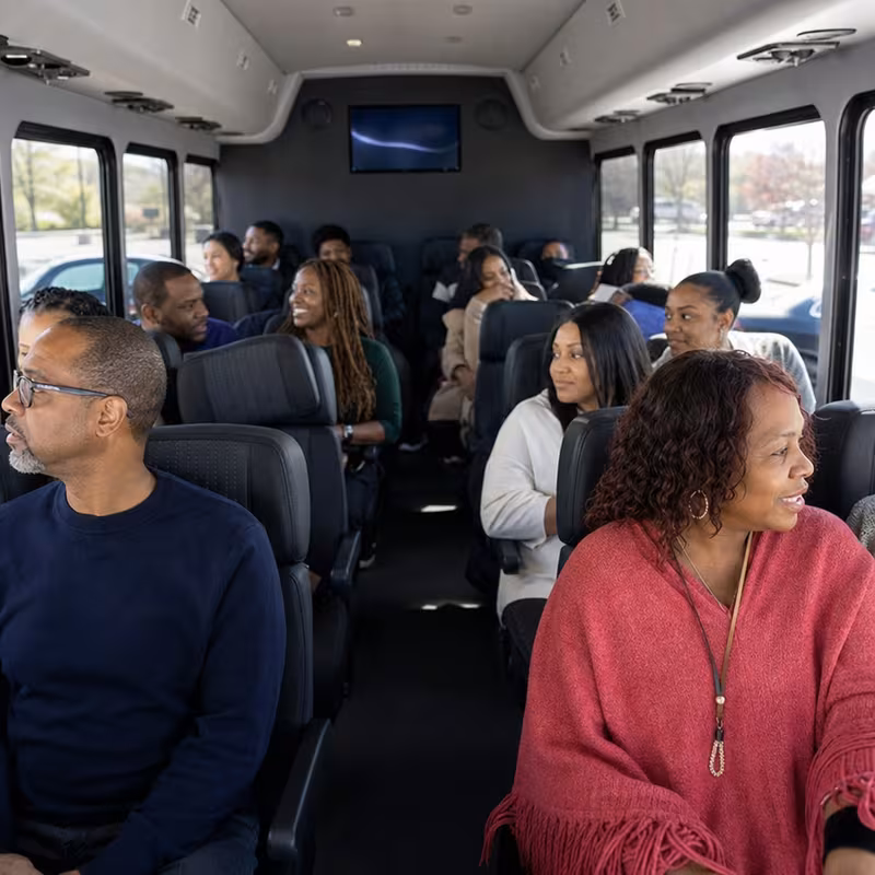 Group boarding a white charter bus for Private Event Transportation transportation in Newark