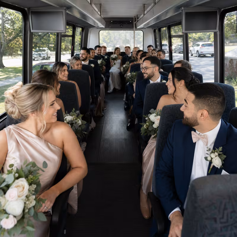 Group boarding a white charter bus for Wedding Transportation transportation in Newark